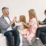A joyful family spends quality time together, playing and bonding on a cozy sofa.